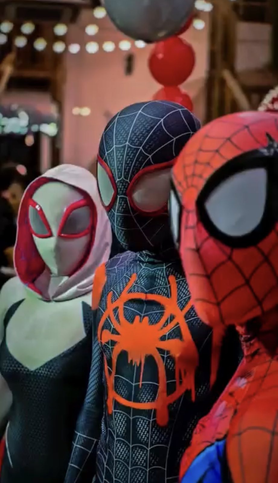 Trio de heróis aranha: Gwen, Miles e o clássico, lado a lado na festa
