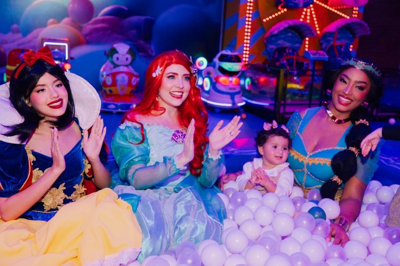 Princesas e uma bebê batendo palminhas na piscina de bolinhas